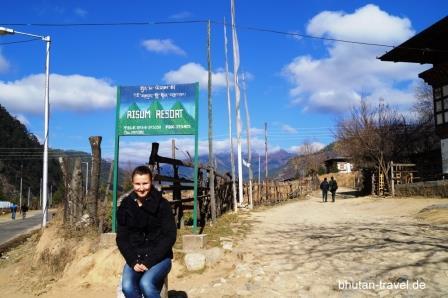 02 Bhutanspezialistin Susanne Huber vor dem Hotelschild des Risum Resort